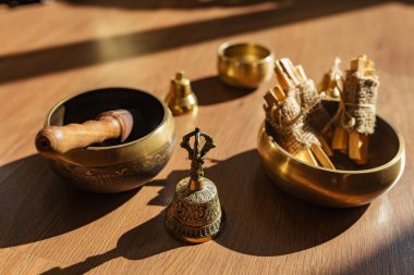 Tibet şarkı kaseleri, çanlar, meditasyon ve ahşap zeminde rahatlama için. Palo Santo ormanı tütsülüyor. Ses masajı ve iyileşme.