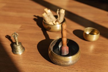 Tibet şarkı kaseleri, çanlar, meditasyon ve ahşap zeminde rahatlama için. Palo Santo ormanı tütsülüyor. Ses masajı ve iyileşme.