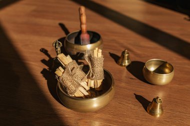 Tibet şarkı kaseleri, çanlar, meditasyon ve ahşap zeminde rahatlama için. Palo Santo ormanı tütsülüyor. Ses masajı ve iyileşme.
