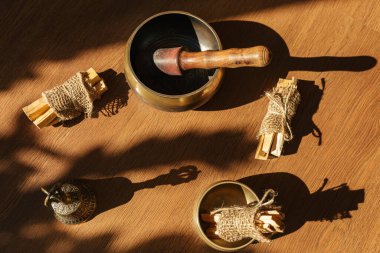 Tibet şarkı kaseleri, çanlar, meditasyon ve ahşap zeminde rahatlama için. Palo Santo ormanı tütsülüyor. Ses masajı ve iyileşme.