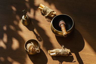 Tibet şarkı kaseleri, çanlar, meditasyon ve ahşap zeminde rahatlama için. Palo Santo ormanı tütsülüyor. Ses masajı ve iyileşme.