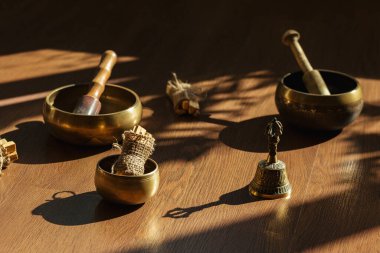 Tibet şarkı kaseleri, çanlar, meditasyon ve ahşap zeminde rahatlama için. Palo Santo ormanı tütsülüyor. Ses masajı ve iyileşme.