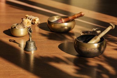 Tibet şarkı kaseleri, çanlar, meditasyon ve ahşap zeminde rahatlama için. Palo Santo ormanı tütsülüyor. Ses masajı ve iyileşme.