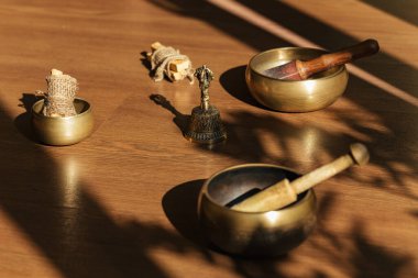 Tibet şarkı kaseleri, çanlar, meditasyon ve ahşap zeminde rahatlama için. Palo Santo ormanı tütsülüyor. Ses masajı ve iyileşme.