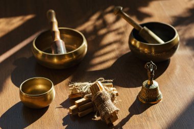 Tibet şarkı kaseleri, çanlar, meditasyon ve ahşap zeminde rahatlama için. Palo Santo ormanı tütsülüyor. Ses masajı ve iyileşme.