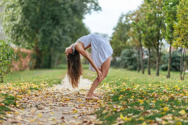 Bella Ragazza Abito Bianco Facendo Yoga Pose Nel Parco Autunnale — Foto Stock