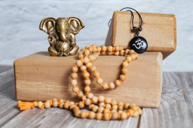 Hindistan 'ın başarı tanrısı Ganesha' nın bronz heykeli. Japon meditasyon aksesuarları ve ahşap arka planda yoga tahtaları..