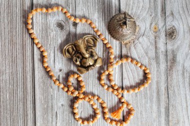 Hindistan 'ın başarı tanrısı Ganesha' nın bronz heykeli. Japon meditasyon aksesuarları, çan ve ahşap arka planda yoga tahtaları..