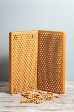 Tibet Budist tespihi, mala ya da japamala deniyor. Kahverengi Sadhu tahta tahtaları, yoga için çiviler ve gri arka planda ruhani uygulamalar. Meditasyon konsepti, tırnakların üzerinde durmak, terapi..