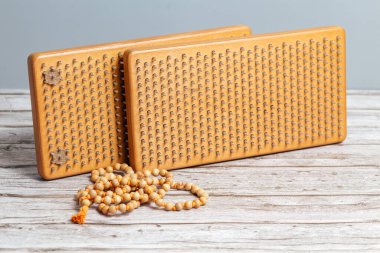 Tibet Budist tespihi, mala ya da japamala deniyor. Kahverengi Sadhu tahta tahtaları, yoga için çiviler ve gri arka planda ruhani uygulamalar. Meditasyon konsepti, tırnakların üzerinde durmak, terapi..