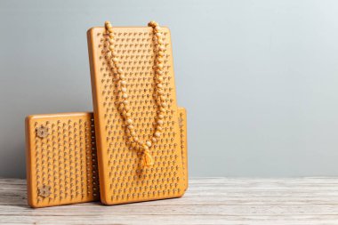 Tibet Budist tespihi, mala ya da japamala deniyor. Kahverengi Sadhu tahta tahtaları, yoga için çiviler ve gri arka planda ruhani uygulamalar. Meditasyon konsepti, tırnakların üzerinde durmak, terapi..