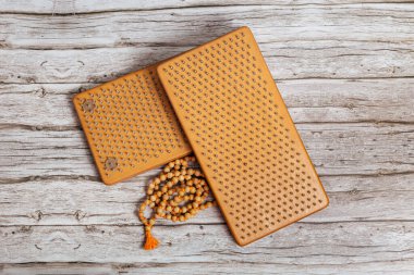 Tibet Budist tespihi, mala ya da japamala deniyor. Kahverengi Sadhu tahta tahtaları, yoga için çiviler ve gri arka planda ruhani uygulamalar. Meditasyon konsepti, tırnakların üzerinde durmak, terapi..