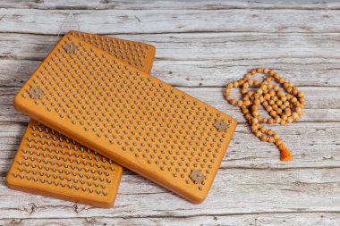 Tibet Budist tespihi, mala ya da japamala deniyor. Kahverengi Sadhu tahta tahtaları, yoga için çiviler ve gri arka planda ruhani uygulamalar. Meditasyon konsepti, tırnakların üzerinde durmak, terapi..