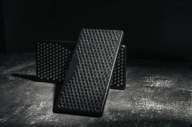 Yakın plan siyah Sadhu tahta tahtaları, yoga için çiviler ve gri arka planda ruhani uygulamalar. Meditasyon konsepti, tırnakların üzerinde durmak, terapi..