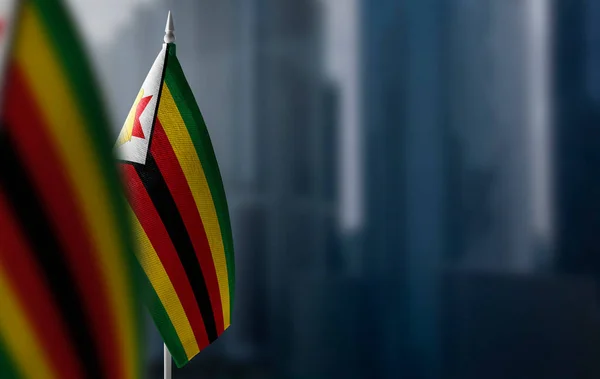 Banderas pequeñas de Zimbabue en un fondo borroso de la ciudad — Foto de Stock