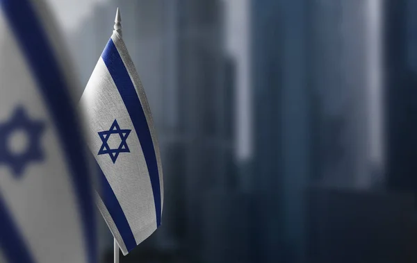 Malé vlajky Izraele na rozmazaném pozadí města — Stock fotografie