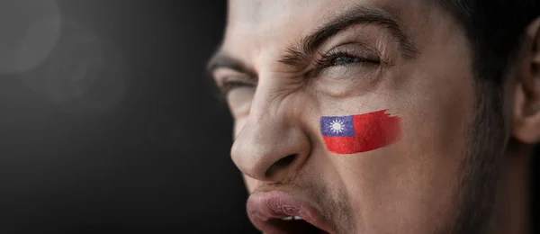 Un hombre gritando con la imagen de la bandera nacional de Taiwán en su cara — Foto de Stock