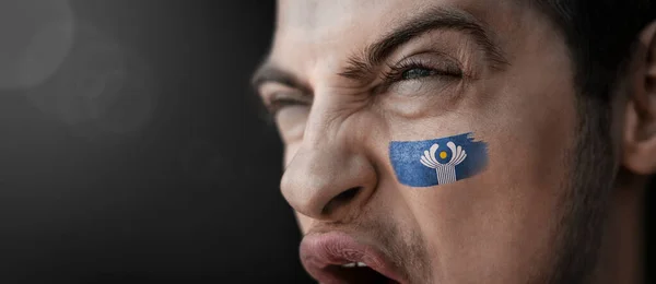 A screaming man with the image of the CIS national flag on his face — Stock Photo, Image