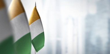 Şehrin bulanık arka planında Cote dIvoire 'ın küçük bayrakları