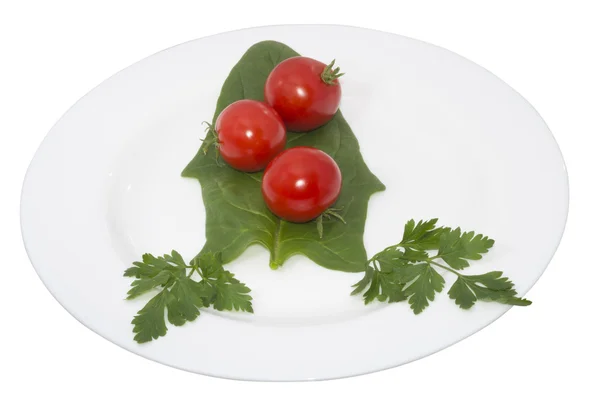 Tomato and greens in a plate, isolated — Stock Photo, Image