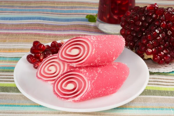 Red candy fruit on a plate with pomegranate Stock Image