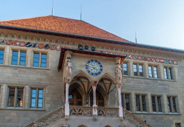 İsviçre 'nin Bern (Berner Rathaus) belediye binasının girişinin görüntüsü. Güzel dekore edilmiş gotik veranda, saat ve armalı..