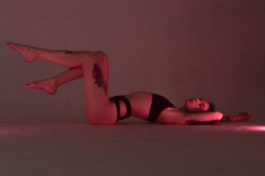 Pembe elbiseli erotik kız iç çamaşırlarıyla yerde yatıyor..