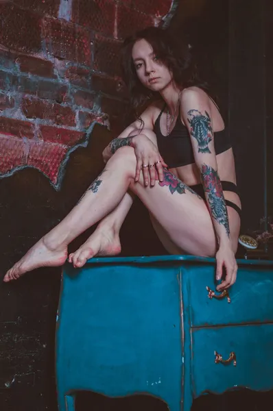 Dziewczyna Tatuażami Siedzi Komodzie Kurtce Bieliźnie — Zdjęcie stockowe