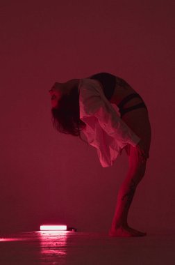 Sırtında pembe neonlu iç çamaşırlı erotik kız.