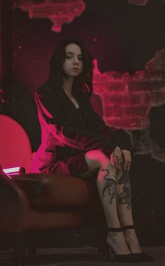 Ceketli bir kız ve kırmızı neonlu seksi ayakkabılar.