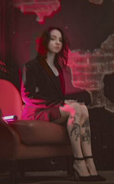 Ceketli bir kız ve kırmızı neonlu seksi ayakkabılar.