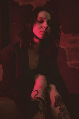 Ceketli bir kız ve kırmızı neonlu seksi ayakkabılar.