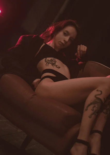 Ceketli bir kız ve kırmızı neonlu seksi ayakkabılar.