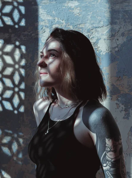 Güneşli bir odada siyah saçlı ve şortlu bir kız.