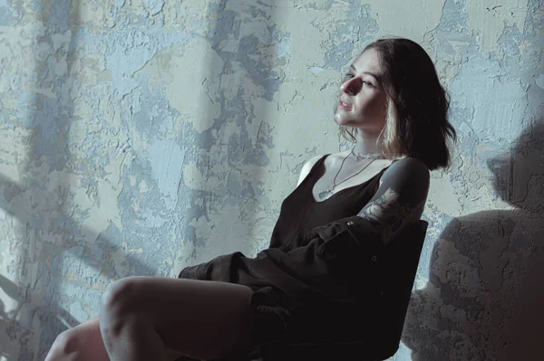 Güneşli bir odada siyah saçlı ve şortlu bir kız.