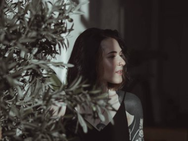 Güneşli bir odada siyah saçlı ve şortlu bir kız.