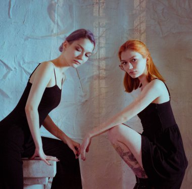 Beyaz arka planda siyah elbiseli ikizler.