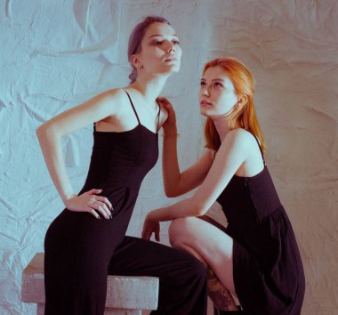 Beyaz arka planda siyah elbiseli ikizler.