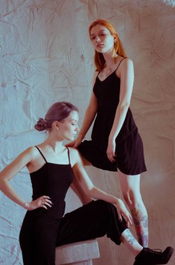 Beyaz arka planda siyah elbiseli ikizler.