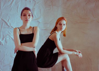 Beyaz arka planda siyah elbiseli ikizler.