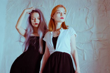 Beyaz arka planda siyah elbiseli ikizler.