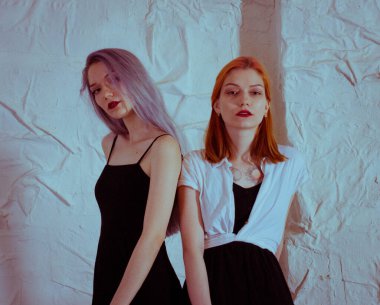 Beyaz arka planda siyah elbiseli ikizler.