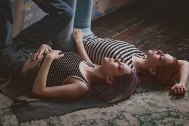 Çizgili tişörtlü ikizler halının üzerinde yatıyor.