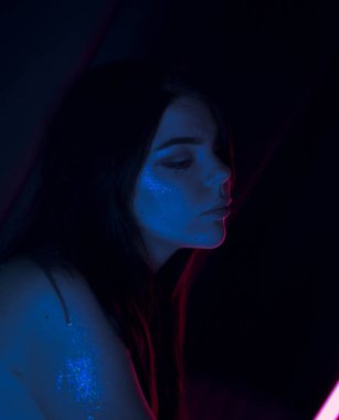 Güzel, uzun saçlı, neonlu, iç çamaşırlı kız.