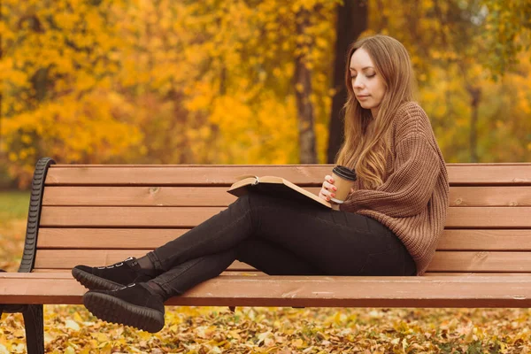 Młoda Kobieta Jesiennym Parku Siedzi Ławce Pije Kawę Czyta Książkę — Zdjęcie stockowe