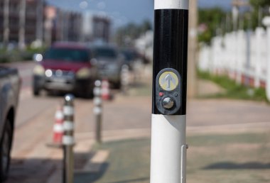 Trafik ışığı için düğmeye bas. Kavşaktaki trafik ışıklarını kullan. Mekanizmanın düğmesi sokaktaki trafik ışıklarını yakıyor. Yaya geçidi Sinyal Düğmesi ve İmzası.