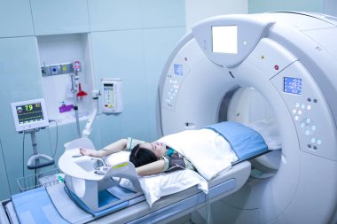 Hastalar tomografide taranıyor. Adam bilgisayarları kullanırken CT taramasından geçiyor. Tomografide inceleme yapan adam. Kullanılan tomografi.