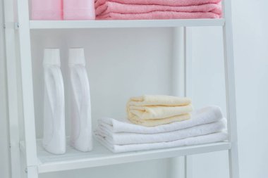 Bir yığın havlu ve çamaşır deterjanı. Havlu ve deterjan yığını. Yıkanırken bir yığın temiz havlu ve deterjan.