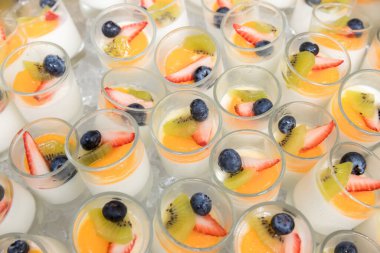 Tofu soslu meyve salatası. Bir fincan puding meyve salatası. Süt kabında tofunun üzerine meyve salatası..