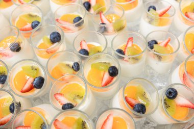 Tofu soslu meyve salatası. Bir fincan puding meyve salatası. Süt kabında tofunun üzerine meyve salatası..